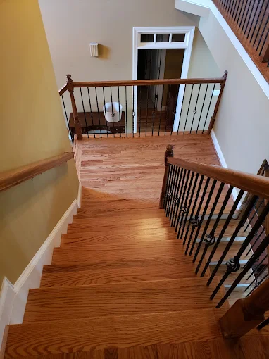 Refinished hardwood staircase with iron balusters